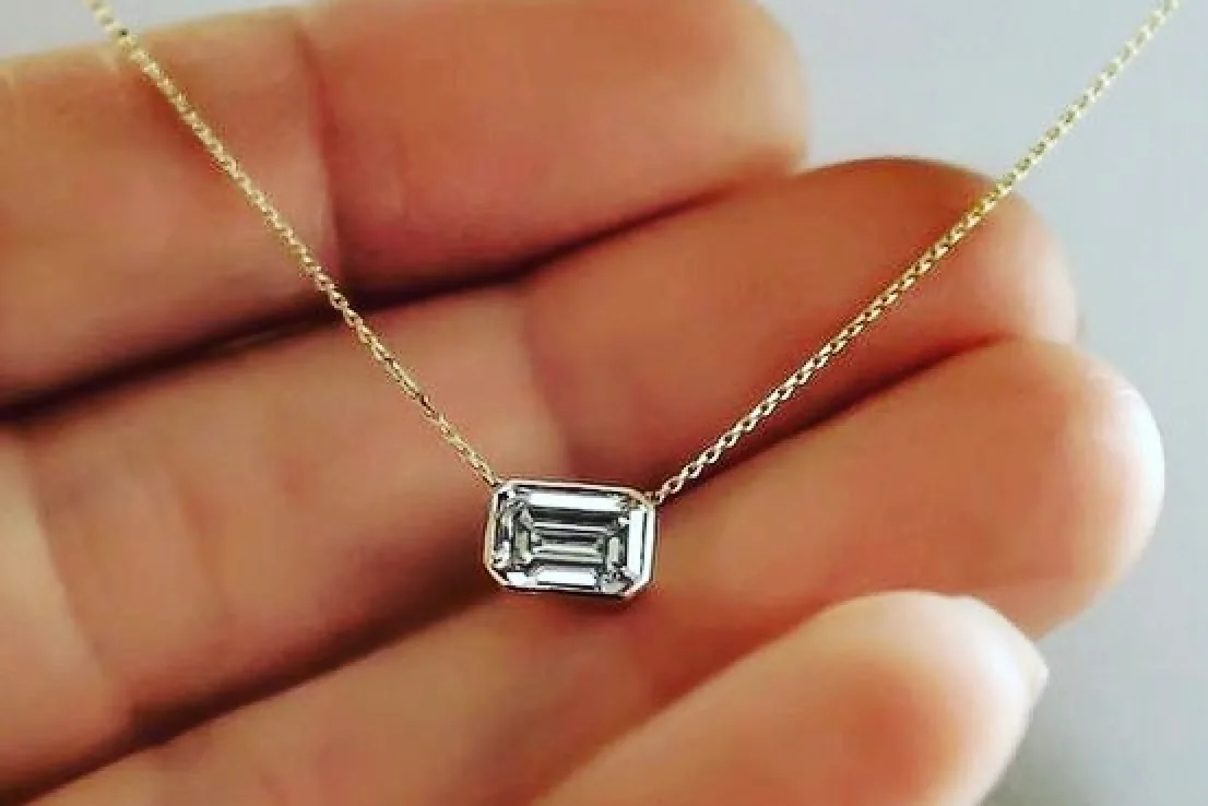 Hand holding one-of-a-kind Eterneva diamond necklace.