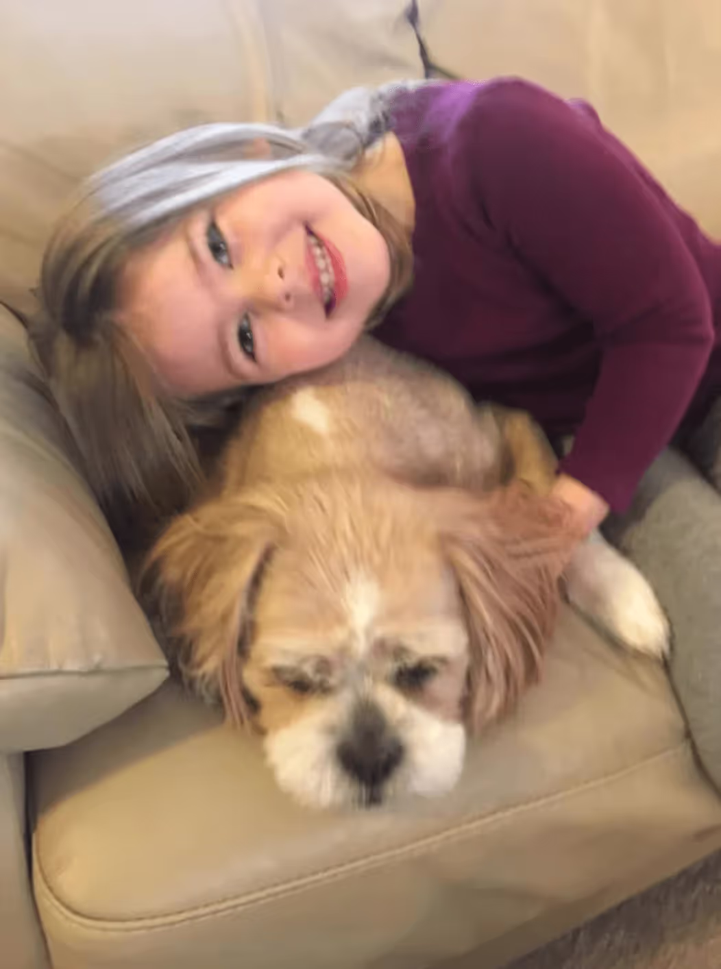 Child hugging Kileigh the dog.