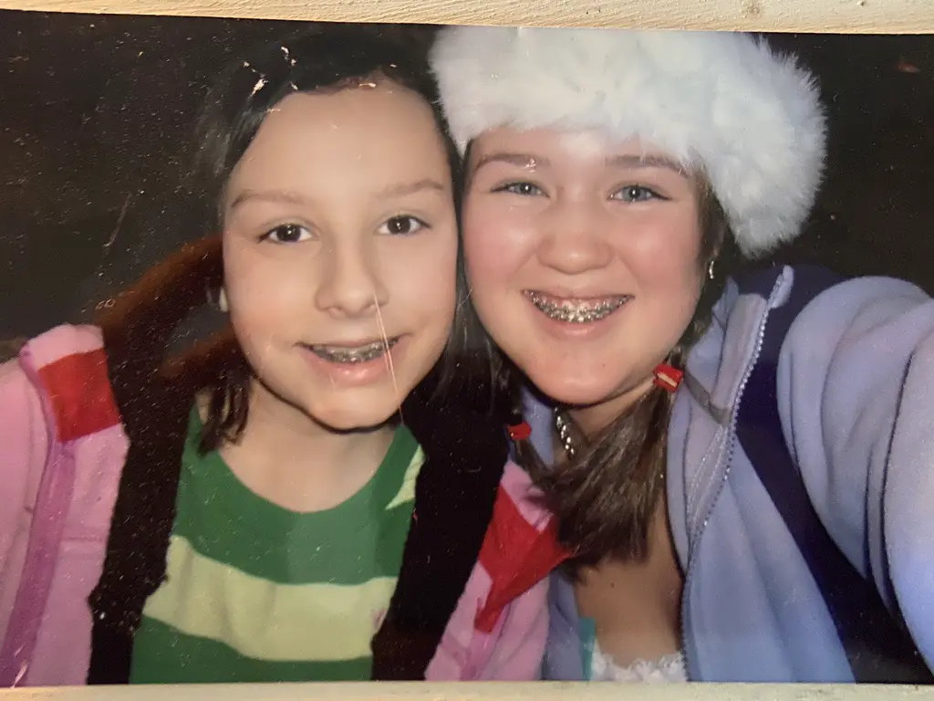 Two young girls smiling cheek to cheek in a close-up selfie.